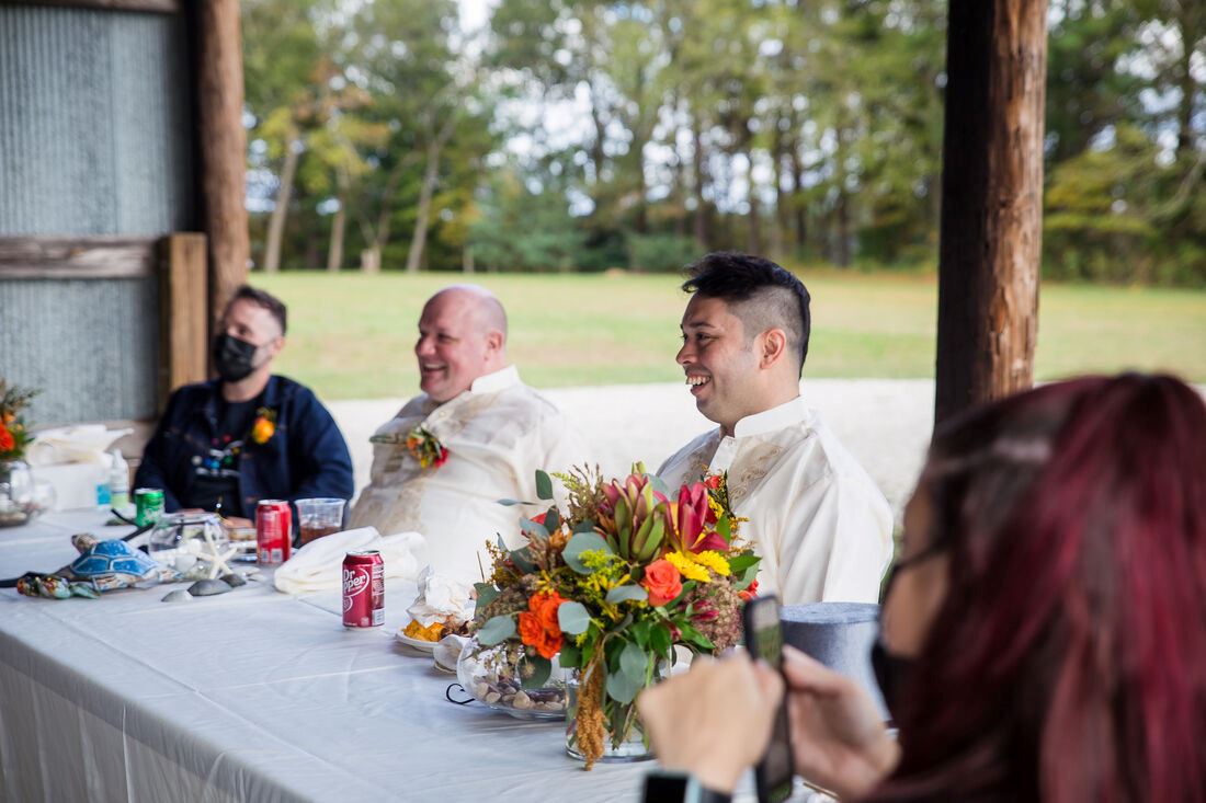 Grooms Smiling at Wedding Dinner